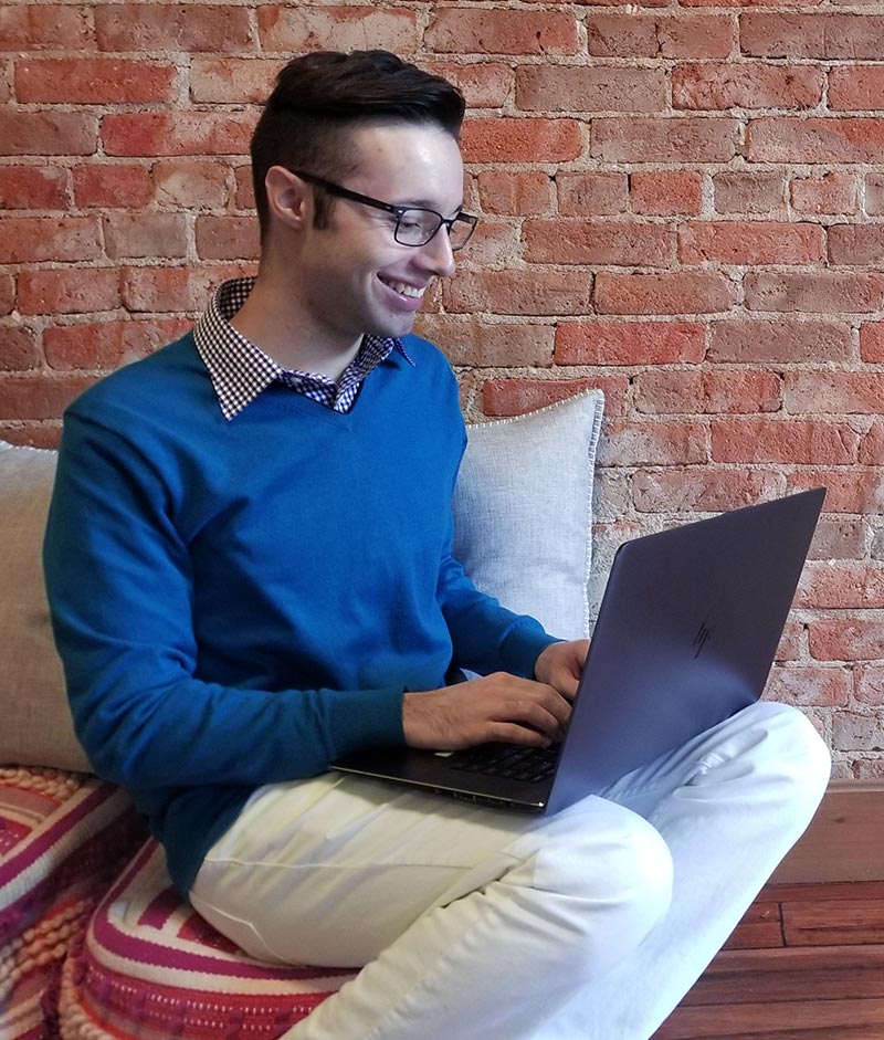 Thomas Maresh, owner of Sakora Studio, working on a laptop in a cute coffee shop
